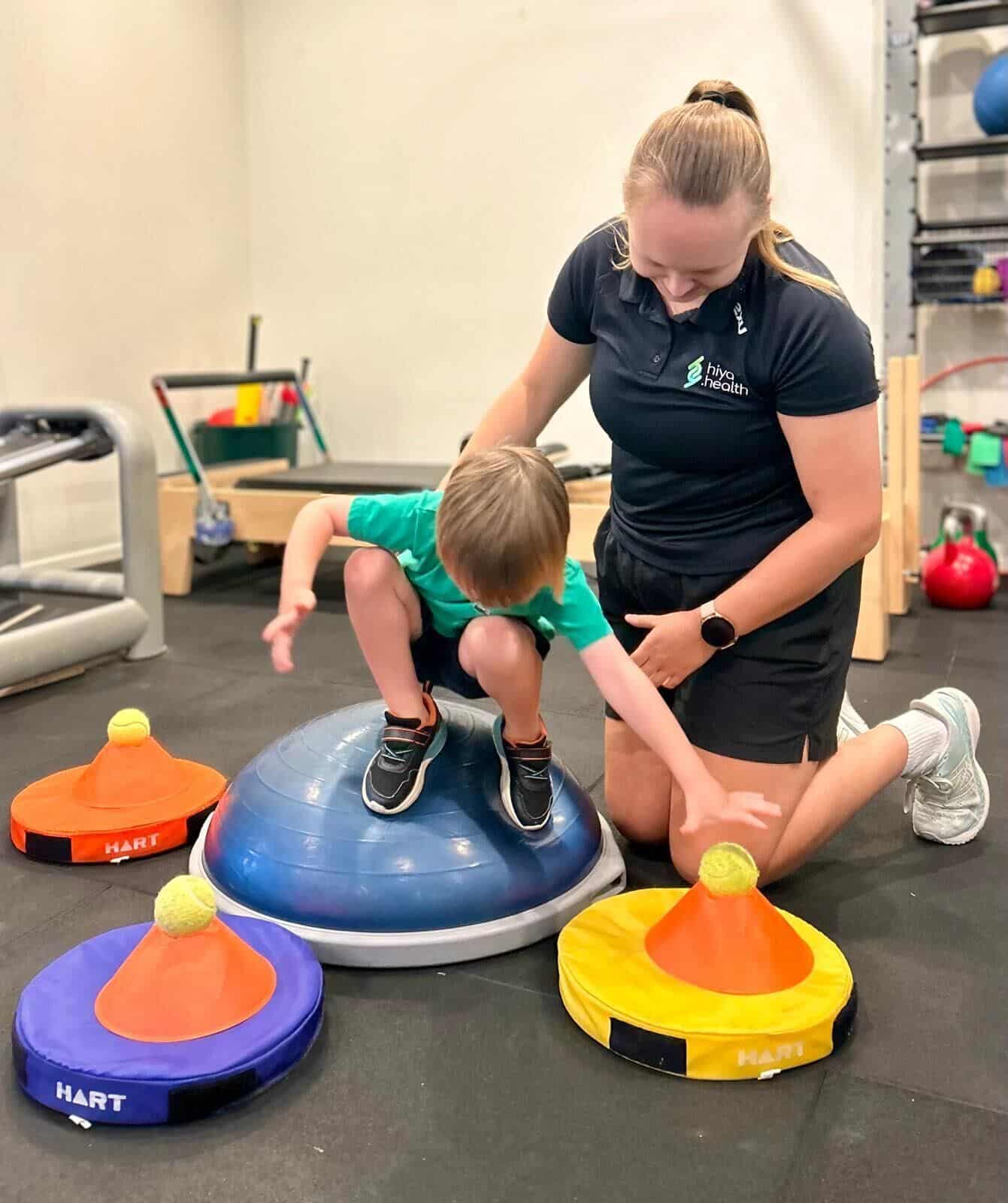 physiotherapist using balancing items for child